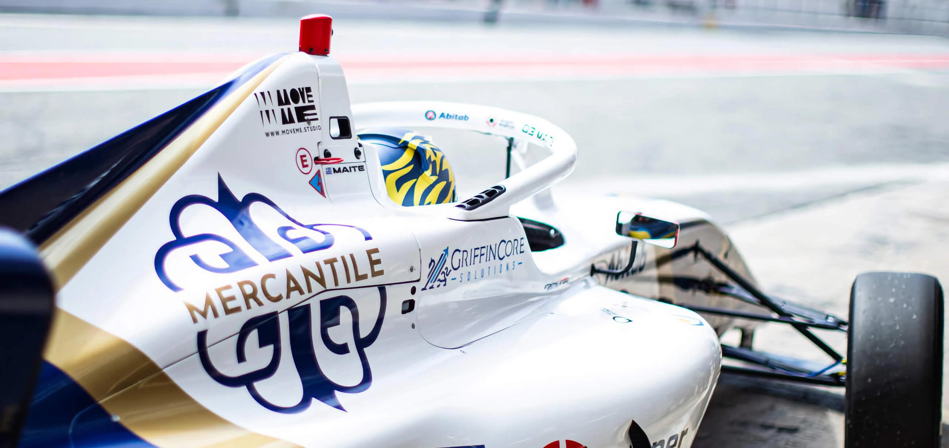 Mercantile Bank International branded race car in the pit lane, part of the bank's F4 racing sponsorship.